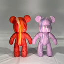 two fluid art bears side by side, one is red orange and yellow, the other is pink lilac and white